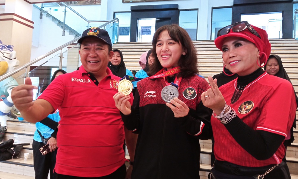 Diapit Bupati dan istri, Febriana Dwipuji Kusuma menunjukkan medali Sea Games (beritalima.com/sugik)